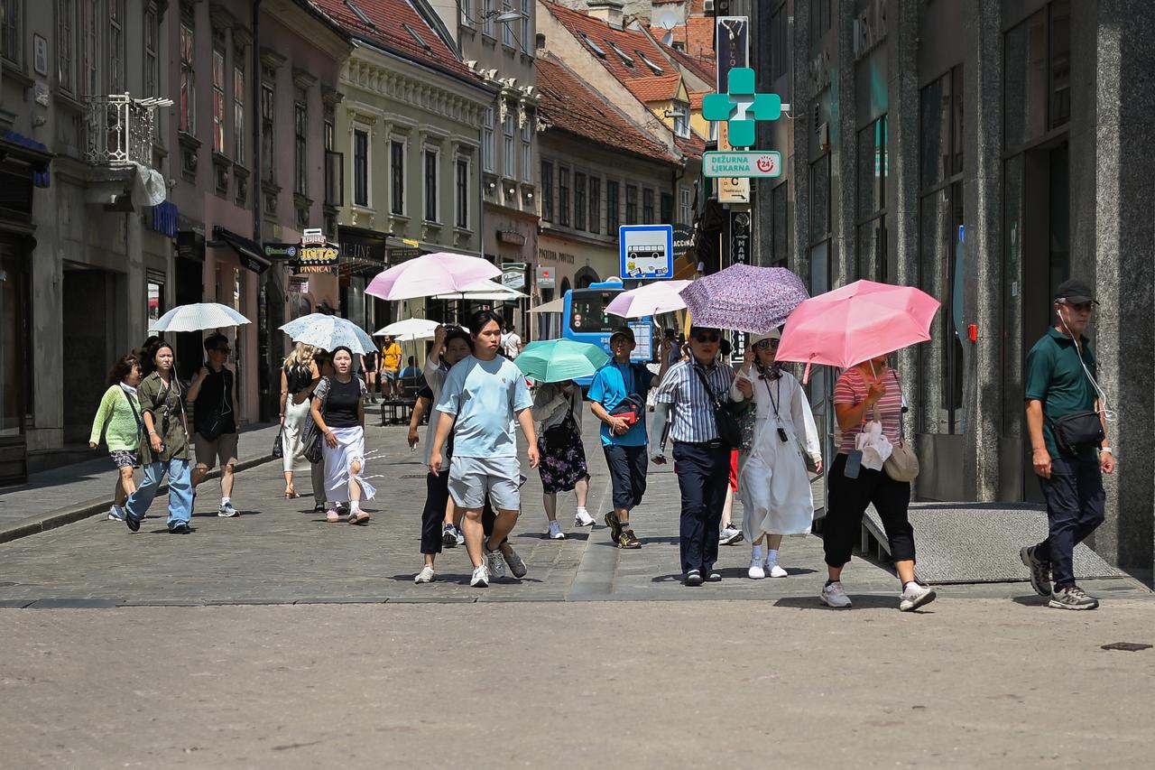 Zagreb: Turisti se od vrućina štite kišobranima 