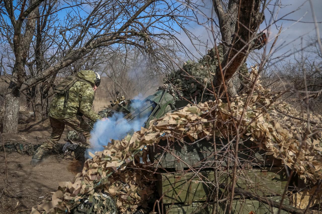 Ukrainian service members fire a towed artillery-piece mortar towards Russian troops, amid Russia's attack on Ukraine, near the town of Bakhmut