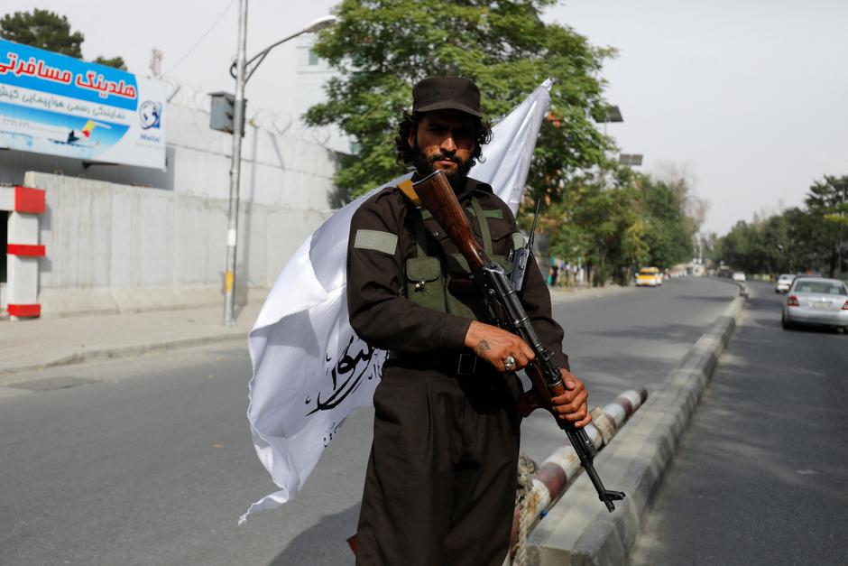 Sangar, a Taliban fighter, poses for a photograph on a street in Kabul