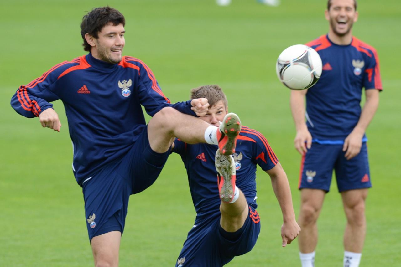 'Russia\'s defender Yuri Zhirkov (L) and Russia\'s striker Andrey Arshavin (C) take part in a training session at the Victoria stadium in Sulejowek on June 14, 2012 at the Euro 2012 football champions