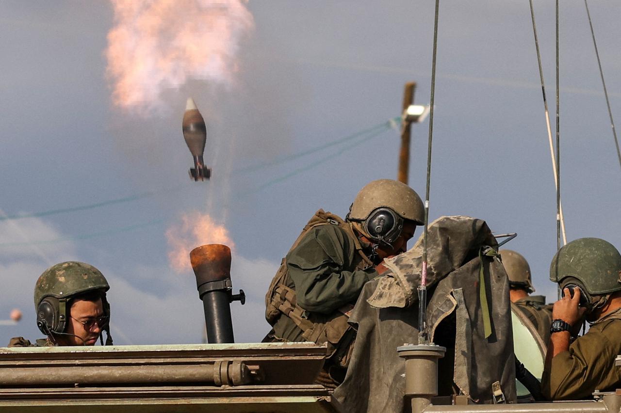 Israeli soldiers fire mortar shells near Israel's border with Gaza in southern Israel
