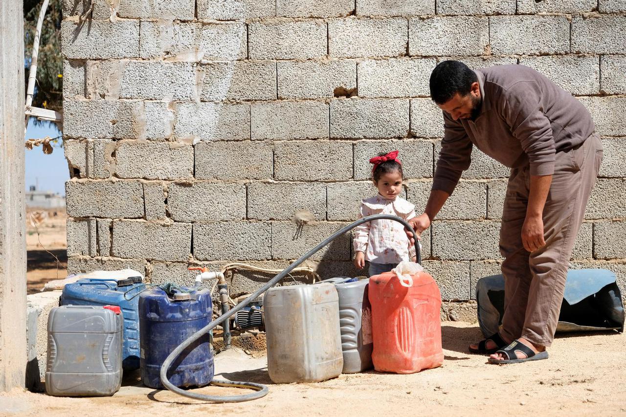 A man fills jerry can with water in Suluq area which experiences shortages in potable water amid contaminations of underground wells, near Benghazi