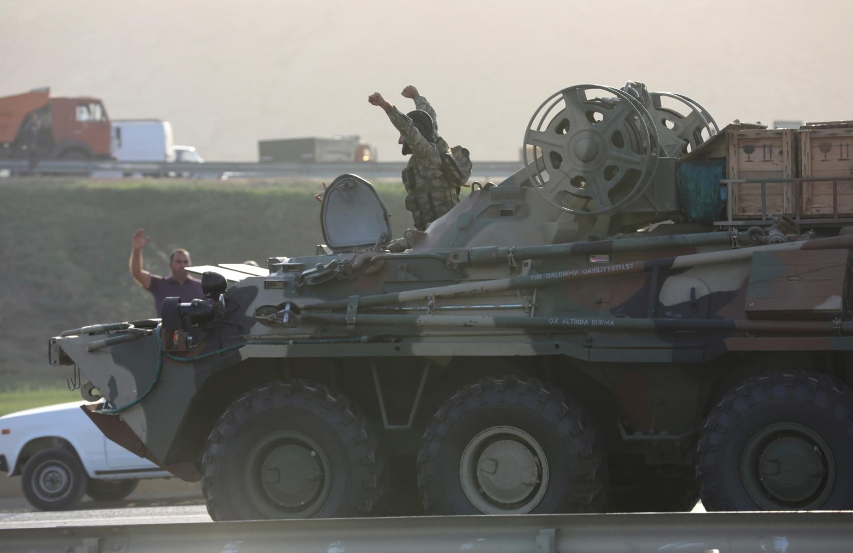 FILE PHOTO: An Azerbaijani service member drives an armoured carrier in Baku FILE PHOTO: An Azerbaijani service member drives an armoured carrier and greets people, who gather on the roadside in Baku, Azerbaijan September 27, 2020. REUTERS/Aziz Karimov/File Photo AZIZ KARIMOV