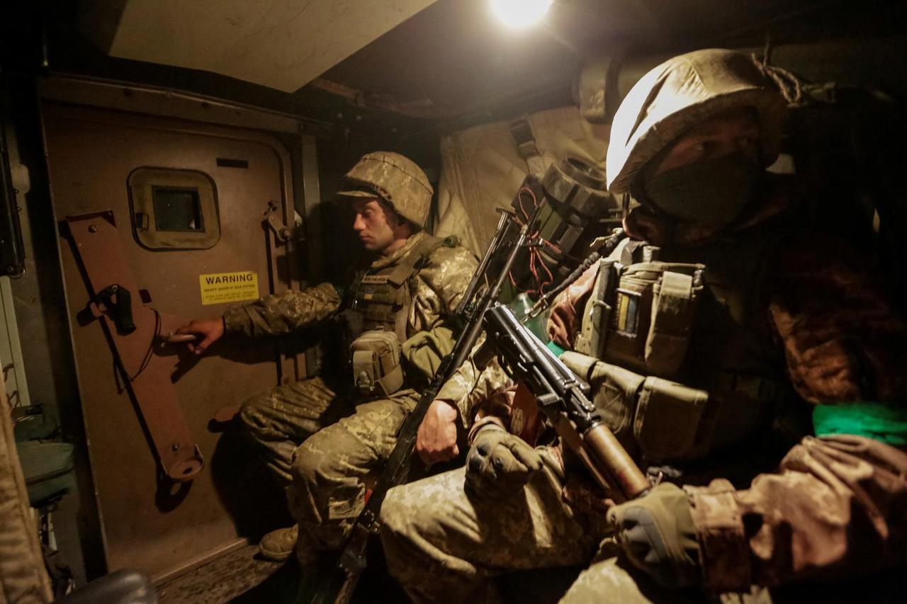 Ukrainian service members ride a Mine Resistant Ambush Protected vehicle near the front line city of Bakhmut