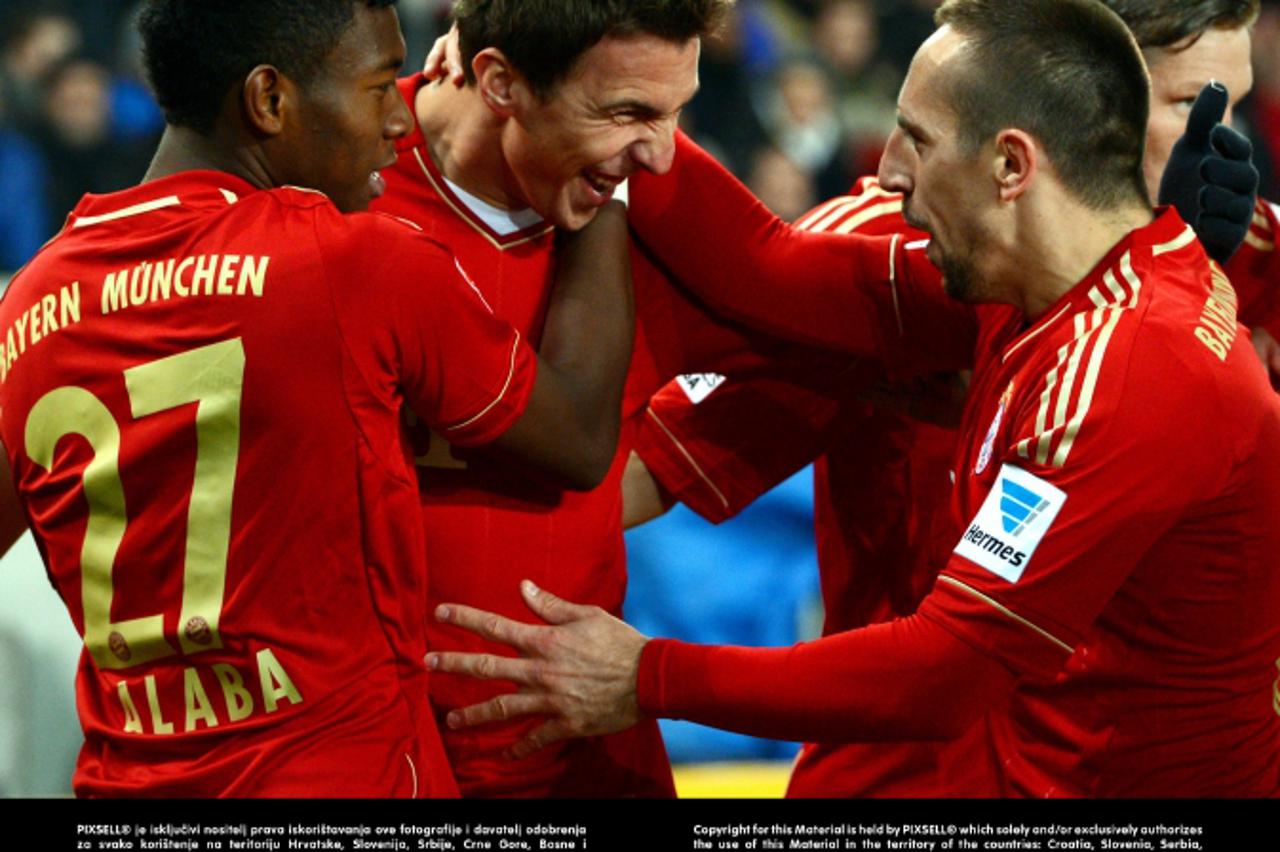 'Munich\'s Mario Mandzukic (C) celebrates his 1-0 goal with David Alaba (L) and Franck Ribery during the German Bundesliga match between VfB Stuttgart and FC Bayern Munich at Mercedes-Benz Arena in St