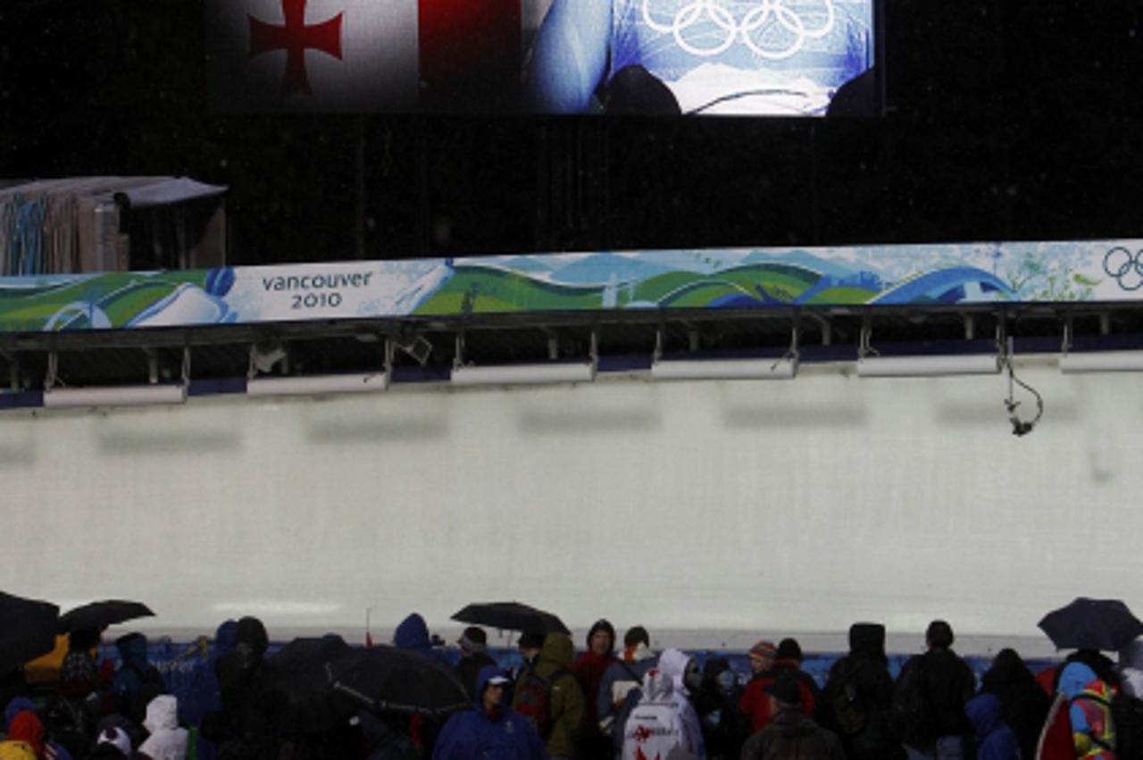 'People observe a moment of silence for Georgian luger Nodar Kumaritashvili, who crashed and died, before the first run of the men\'s singles luge event at the Vancouver 2010 Winter Olympics in Whistl