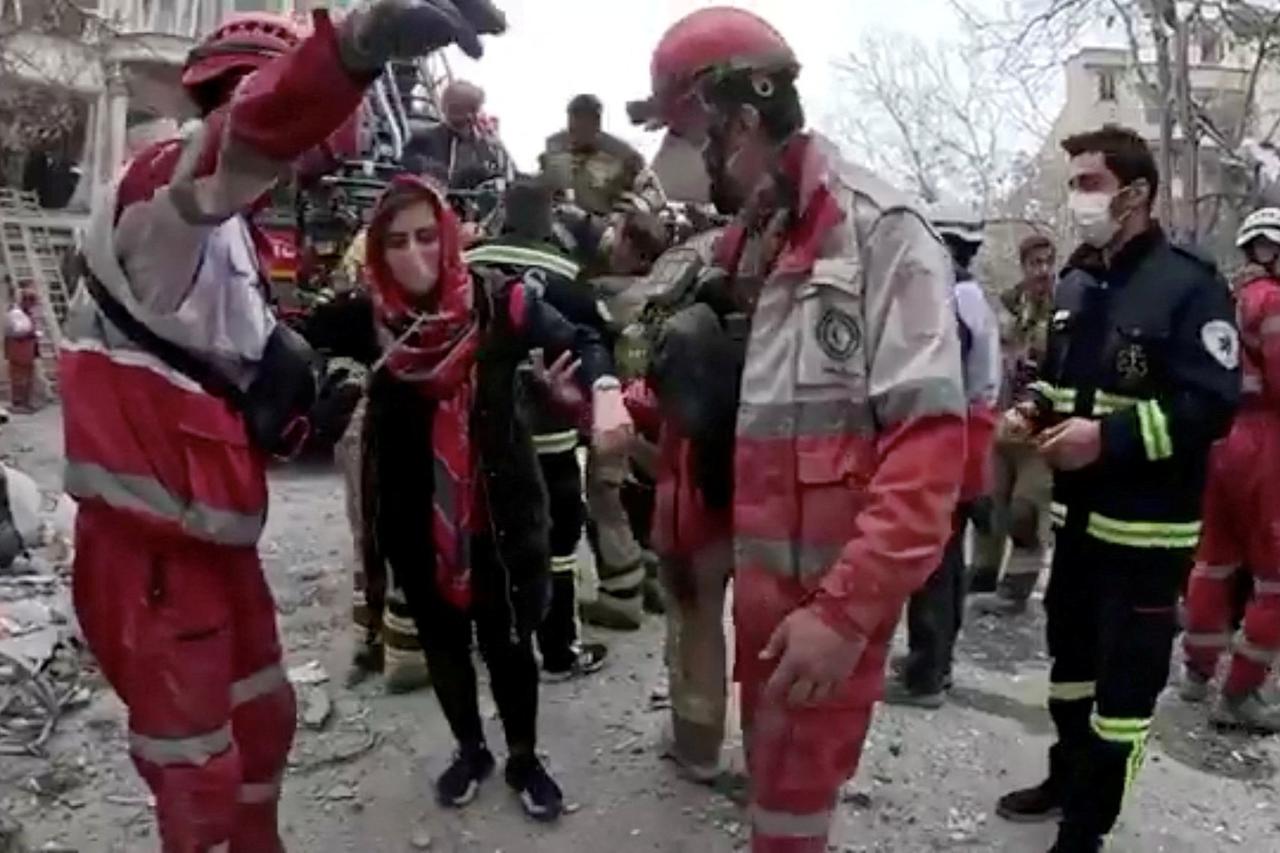 A woman is helped by emergency personnel following a reported strike in Tehran
