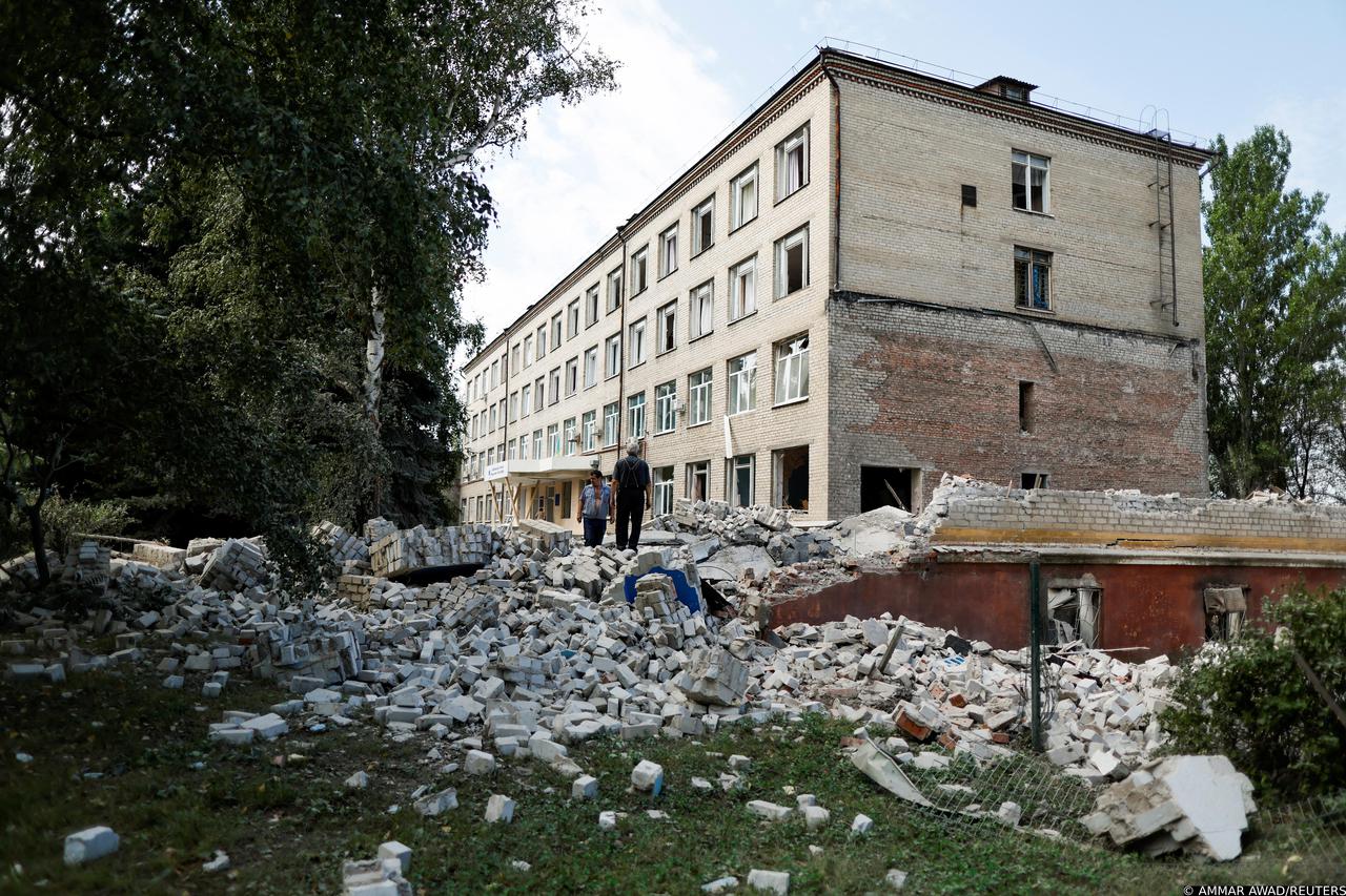 University employees inspect the damage of a destroyed engineering college building in Kramatorsk