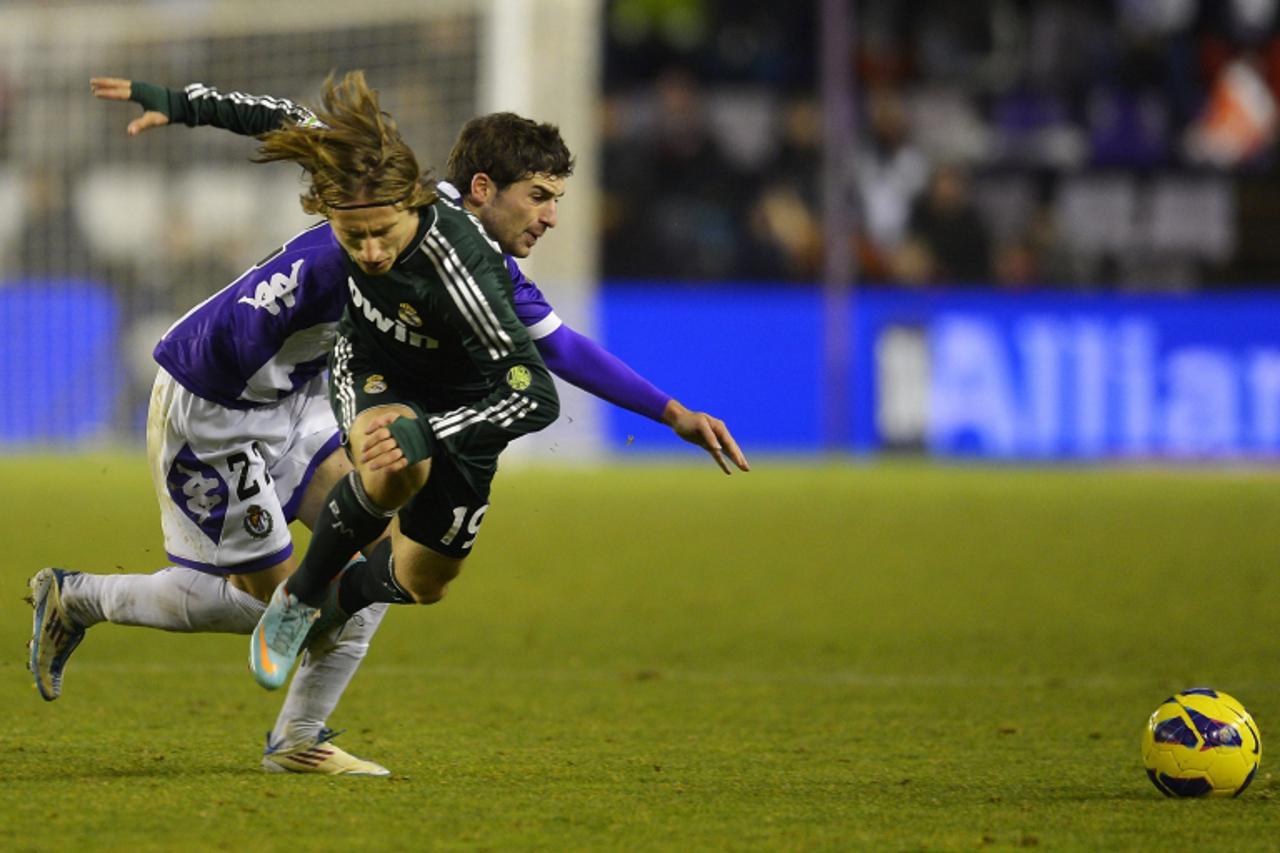 'Real Madrid\'s Luka Modric (front) fights for the ball with Real Valladolid\'s Victor Perez during their Spanish First Division soccer match at Zorrilla Stadium in Valladolid December 8, 2012. REUTER