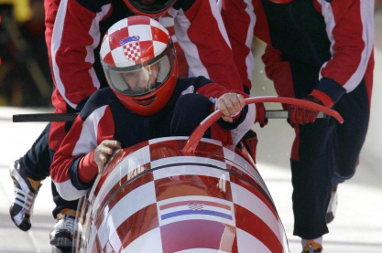 'Team Croatia 1 led by pilot Ivan Sola jump into their bobsleigh during an official four-man bobsleigh training run for the Torino 2006 Winter Olympic Games in Cesana Pariol, Italy February 21, 2006. 