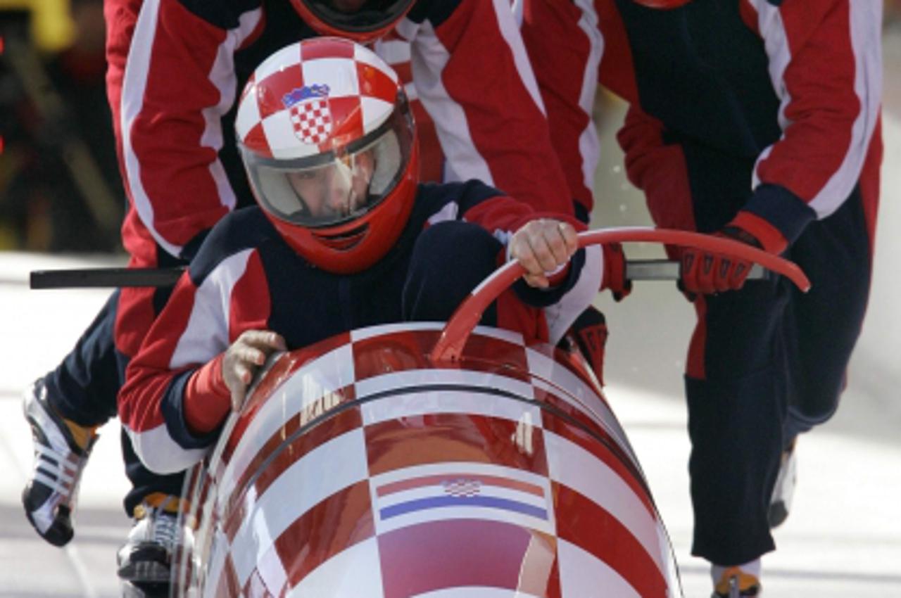 'Team Croatia 1 led by pilot Ivan Sola jump into their bobsleigh during an official four-man bobsleigh training run for the Torino 2006 Winter Olympic Games in Cesana Pariol, Italy February 21, 2006. 