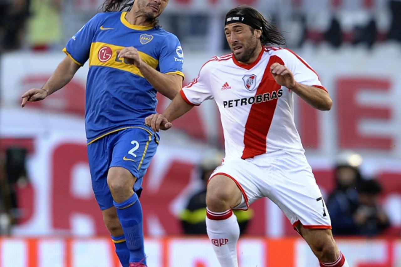 'Boca Juniors\' defender Christian Cellay (L) vies for the ball with forward Mariano Pavone of River Plate, during their Argentina first division football match, at Antonio Liberti stadium in Buenos A