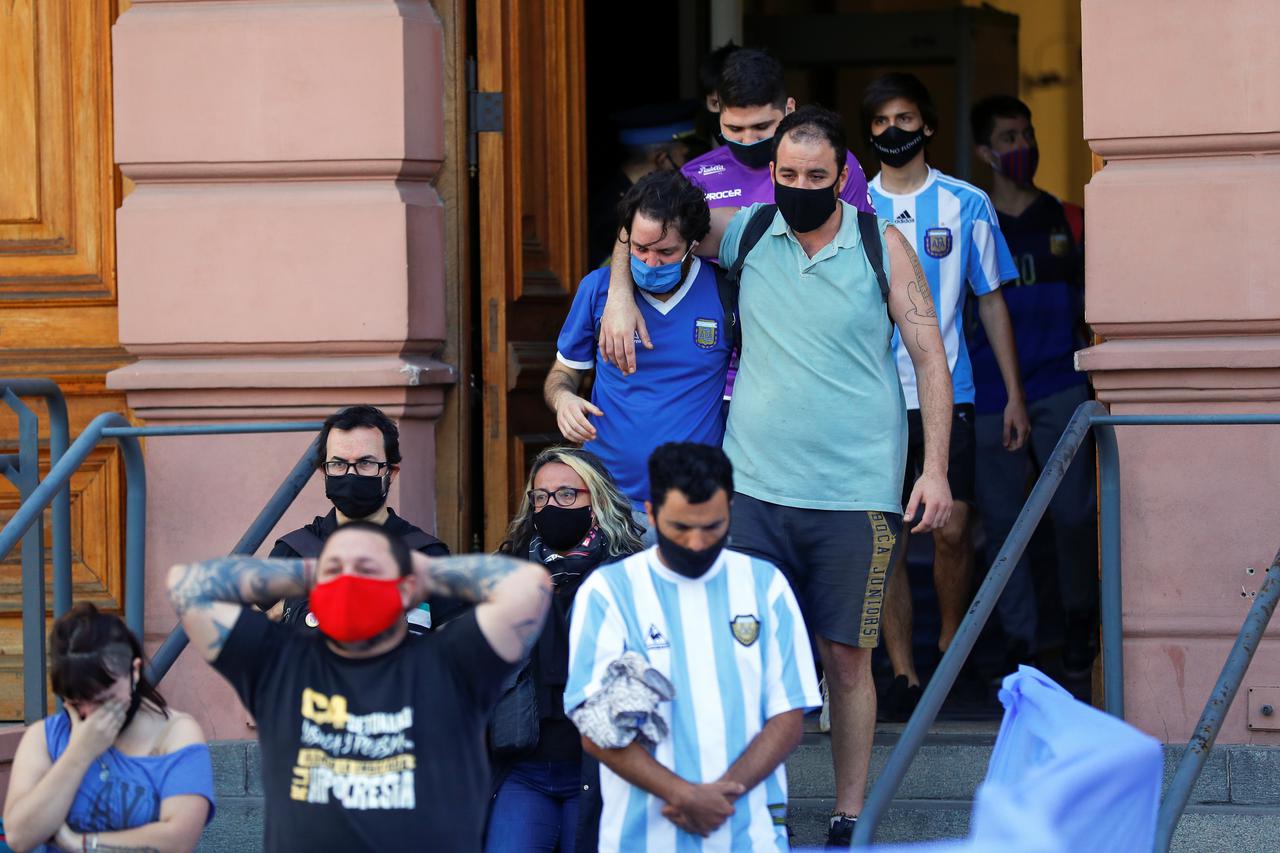 People leave the Casa Rosada presidential palace after attending the wake of late soccer legend Diego Maradona, in Buenos Aires