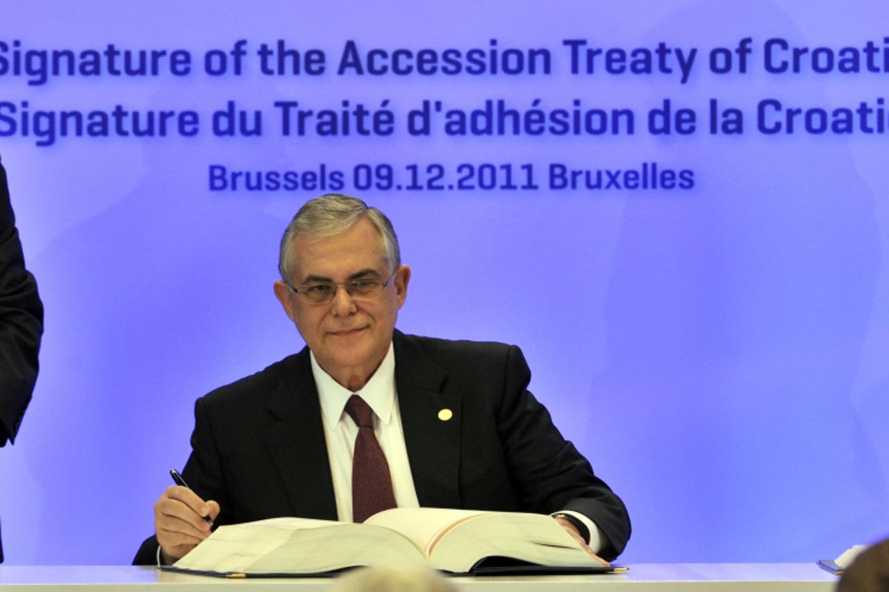 'Greek Prime Minister Lucas Papademos signs Croatia\'s EU accession treaty, on the sidelines of an European Union summit at the EU headquarters on December 9, 2011 in Brussels. Croatia signed an EU ac