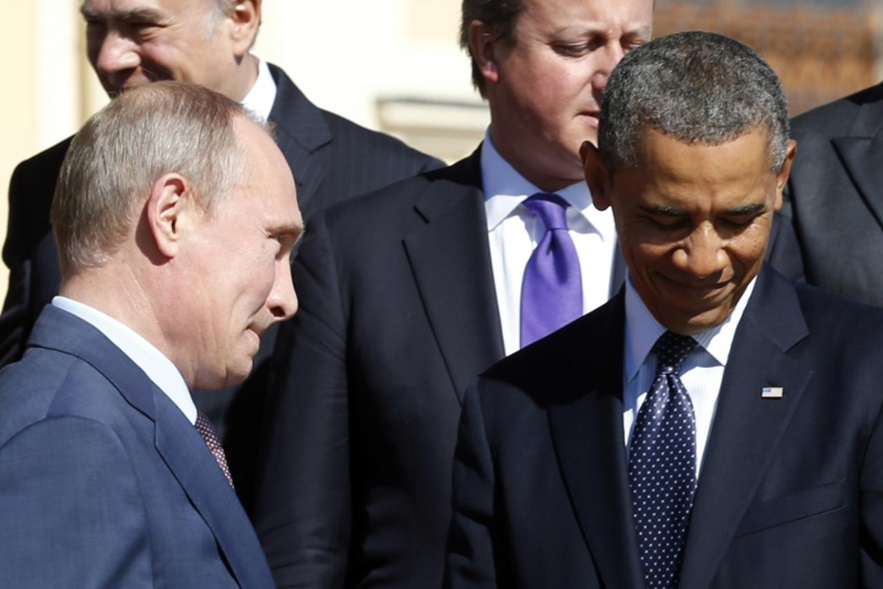 'Russian President Vladimir Putin (L) walks past U.S. President Barack Obama (R) during a group photo at the G20 Summit in St. Petersburg September 6, 2013.   REUTERS/Kevin Lamarque  (RUSSIA - Tags: P