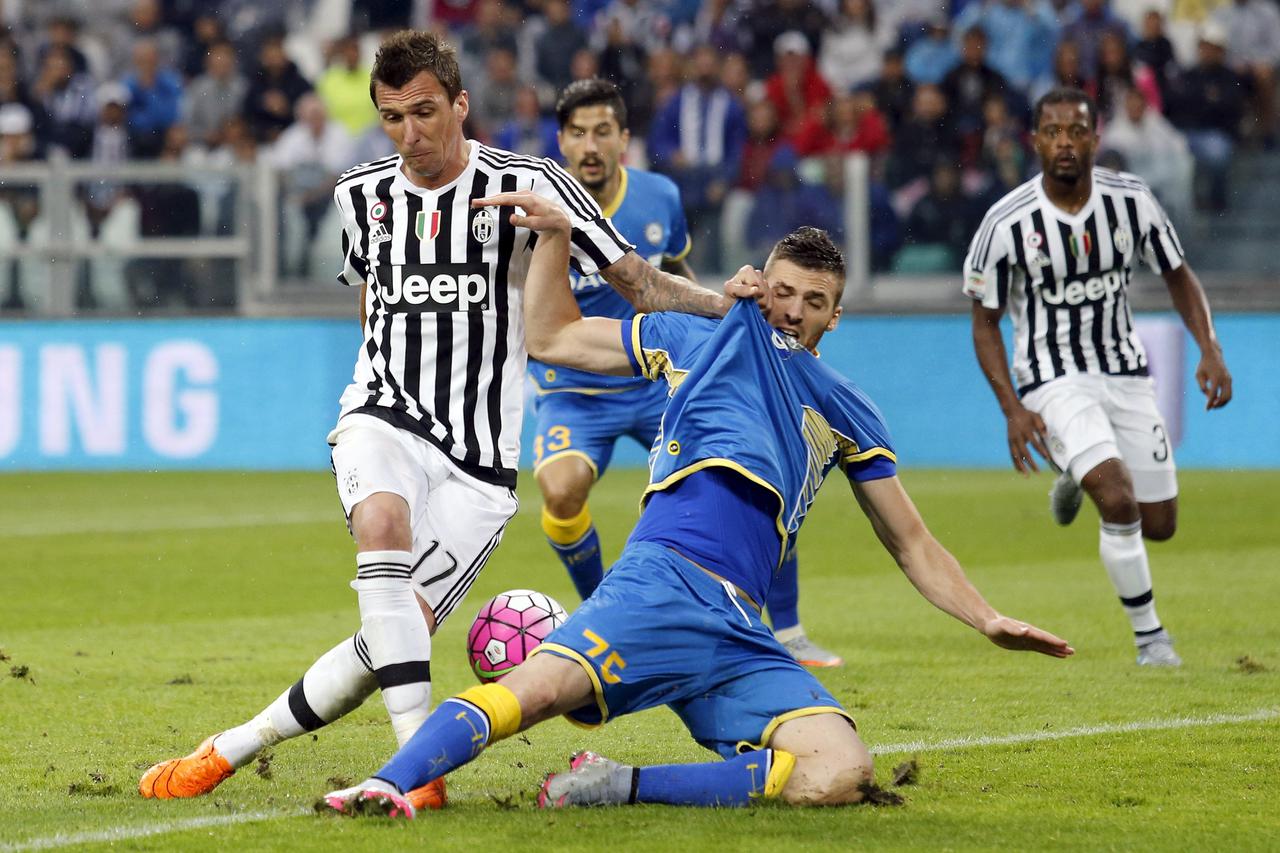 Juventus' Mario Mandzukic (L) and Udinese's Cyril Thereau fight for the ball during their Serie A soccer match at Juventus stadium in Turin August 23, 2015. REUTERS/Giampiero Sposito