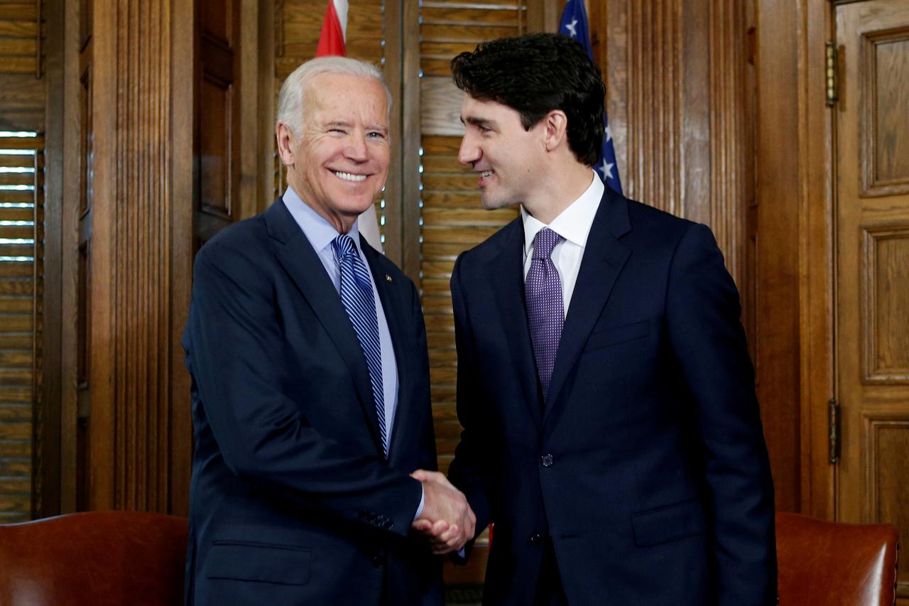 FILE PHOTO: Canada's PM Trudeau shakes hands with U.S. Vice President Biden during a meeting in Trudeau's office on Parliament Hill in Ottawa