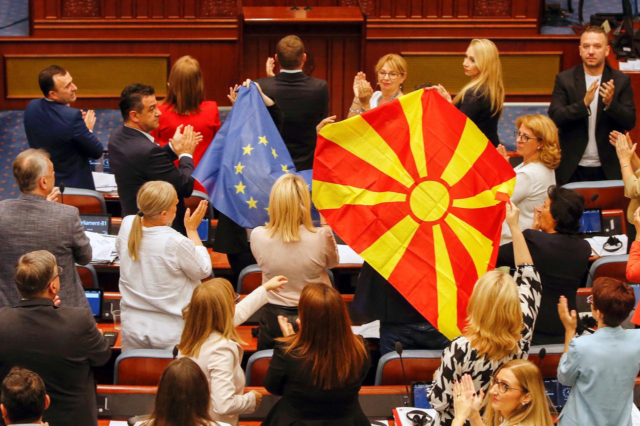 North Macedonia's SDSM party members of Parliament hold EU and Macedonian flags during debate on a French-brokered deal, in Skopje