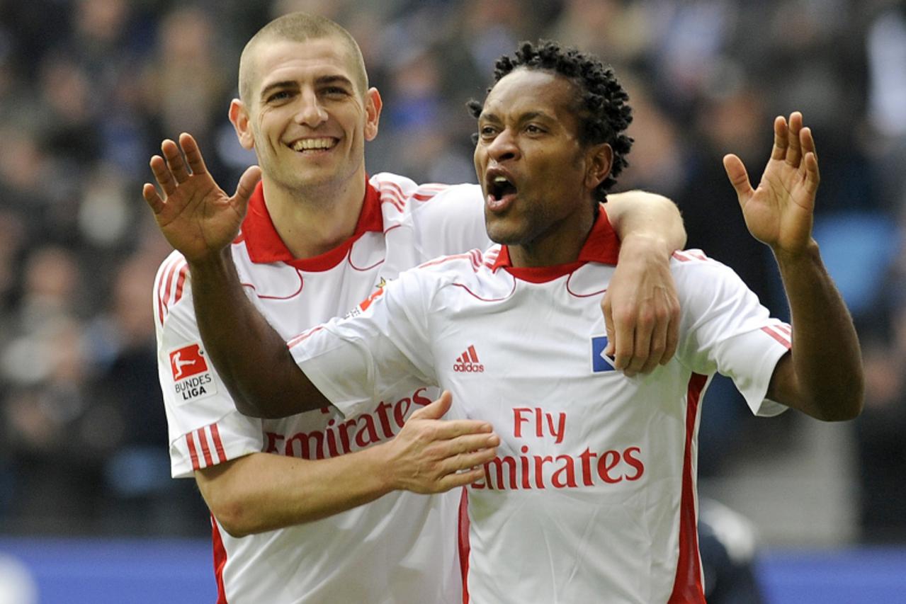 'Hamburg\'s Mladen Petric (L) and Ze Roberto (R) celebrate after scoring during their German Bundesliga soccer match Hamburger SV vs. 1. FC Cologne in Hamburg, March 19, 2011. REUTERS/Fabian Bimmer (G
