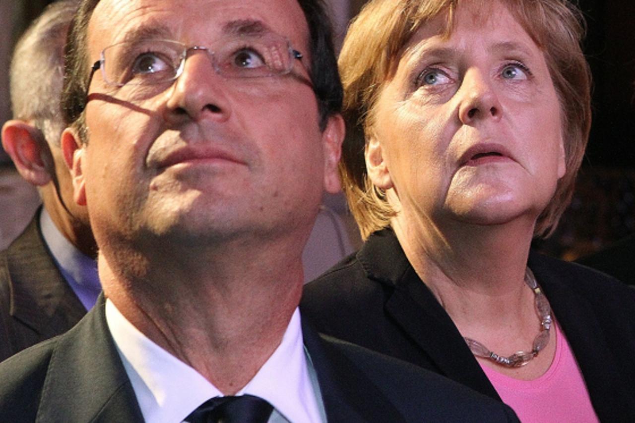 '(LtoR) French President Francois Hollande and German Chancellor Angela Merkel visit the Cathedral on July 8, 2012 in the northern French city of Reims, during a day of ceremonies to commemorate the 5