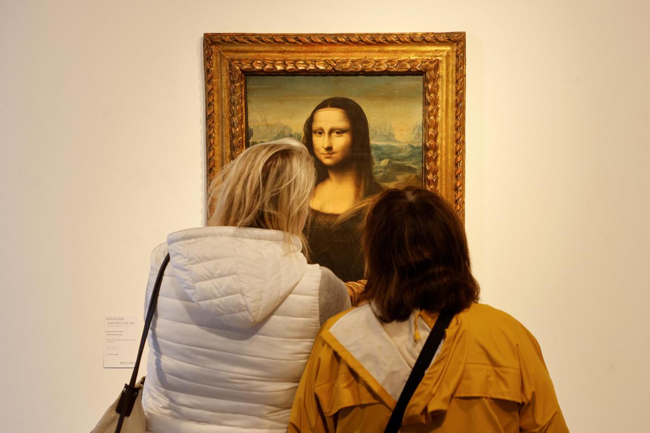 People look at a reproduction painting of Mona Lisa at a gallery in Vienna