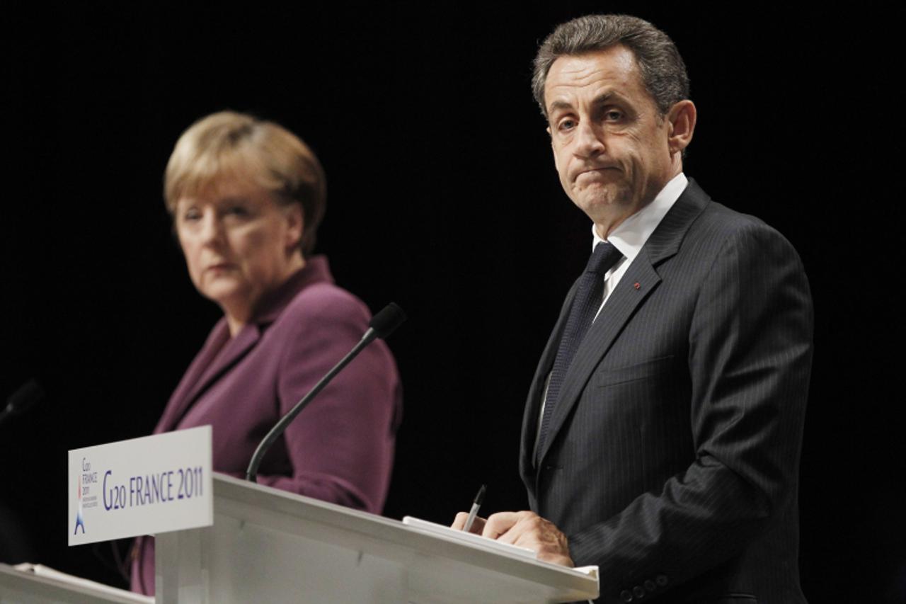 'epa02990166 French President Nicolas Sarkozy (R) and German Chancellor Angela Merkel (L) hold a press conference, in Cannes, France, 02 November 2011, at the end of the emergency meeting set up to di