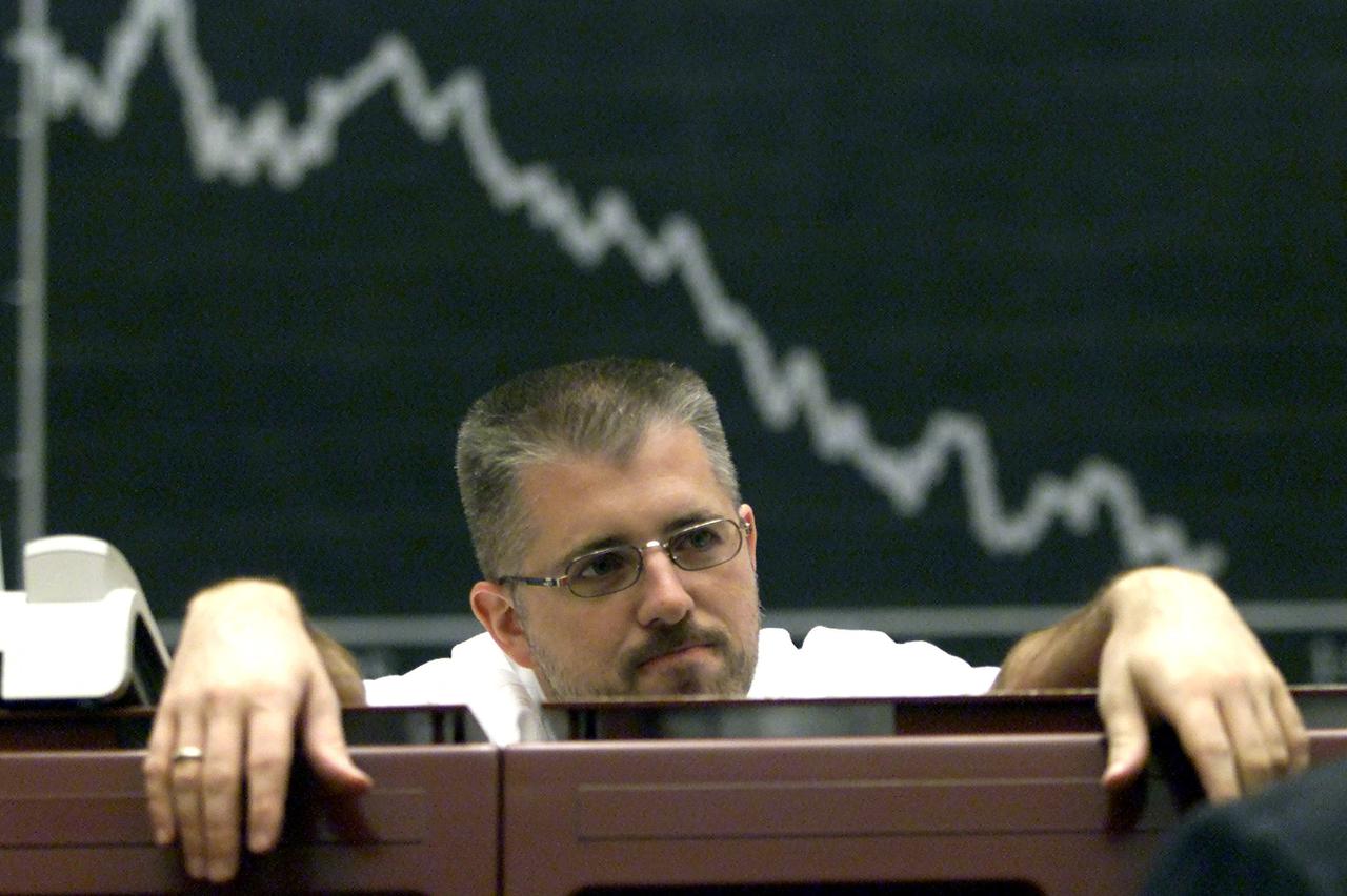 FILE PHOTO: A broker is seen under the board of the DAX (German stock market index) at Frankfurt's stock exchang..