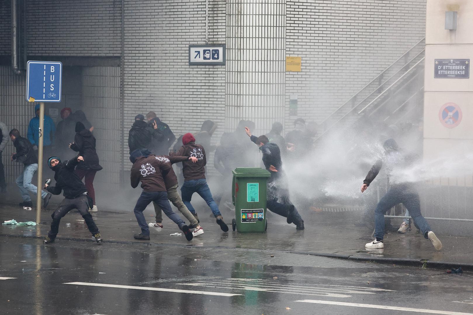 A person throws a bottle as water is spayed during a protest of European farmers over price pressures, taxes and green regulation, on the day of an EU Agriculture Ministers meeting in Brussels, Belgium February 26, 2024. REUTERS/Yves Herman Photo: YVES HERMAN/REUTERS
