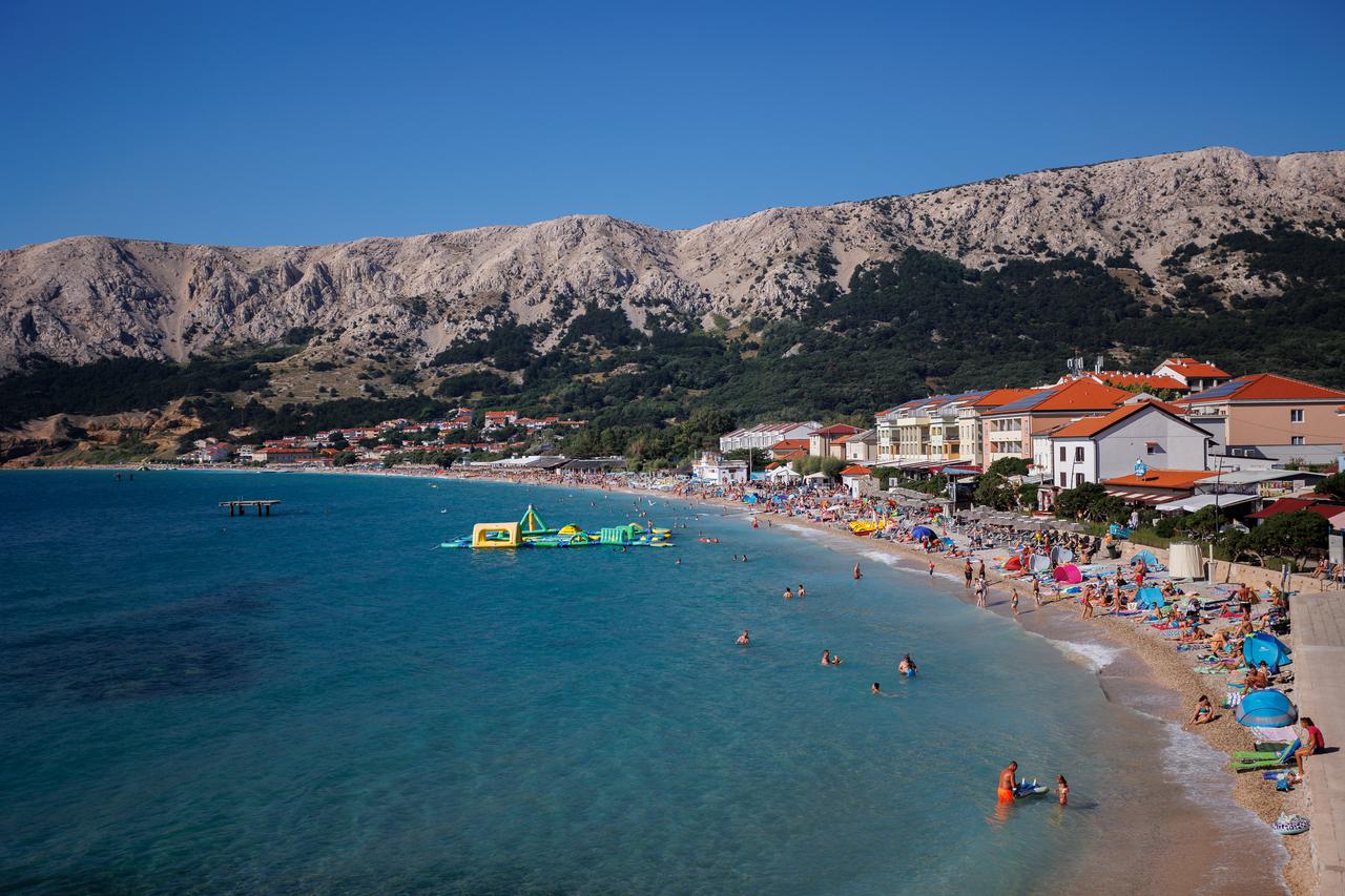 Glavna plaža u Baški puna je posjetitelja koji uživaju u moru