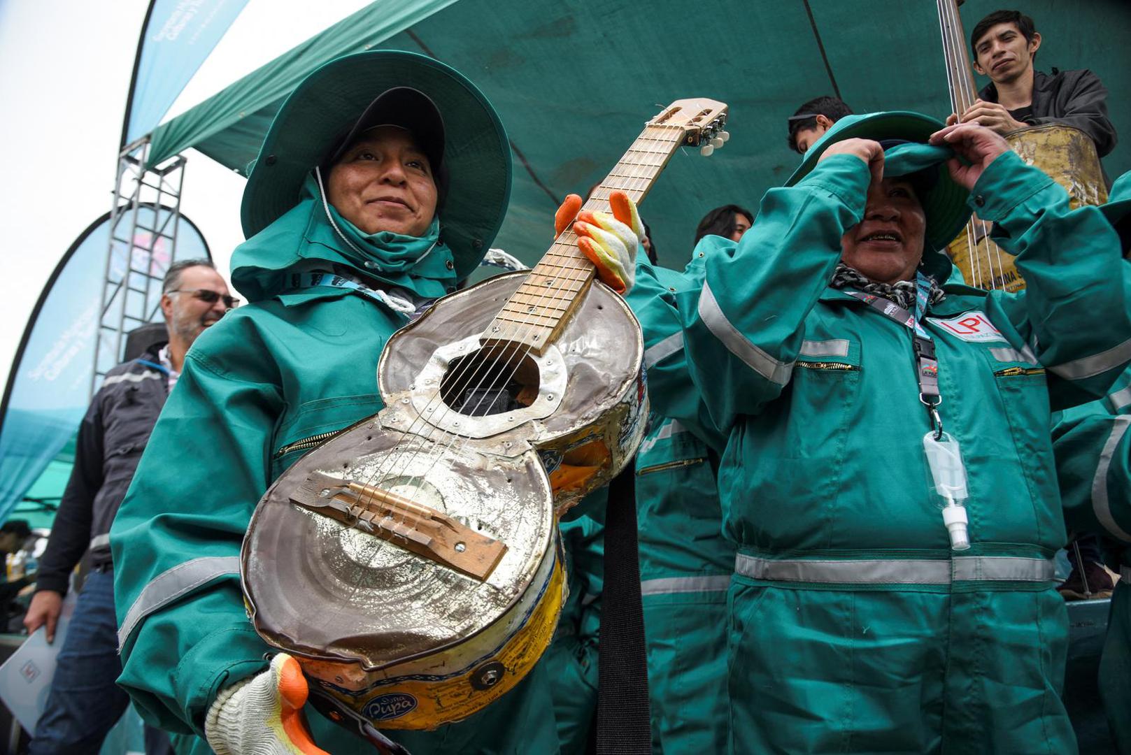 Women waste pickers from the city of La Paz pose near the musicians of the Paraguayan Cateura Recycled Instruments Orchestra, at the Sak'a Churu landfill in Alpacoma, in La Paz, Bolivia February 27, 2023. REUTERS/Claudia Morales Photo: CLAUDIA MORALES/REUTERS