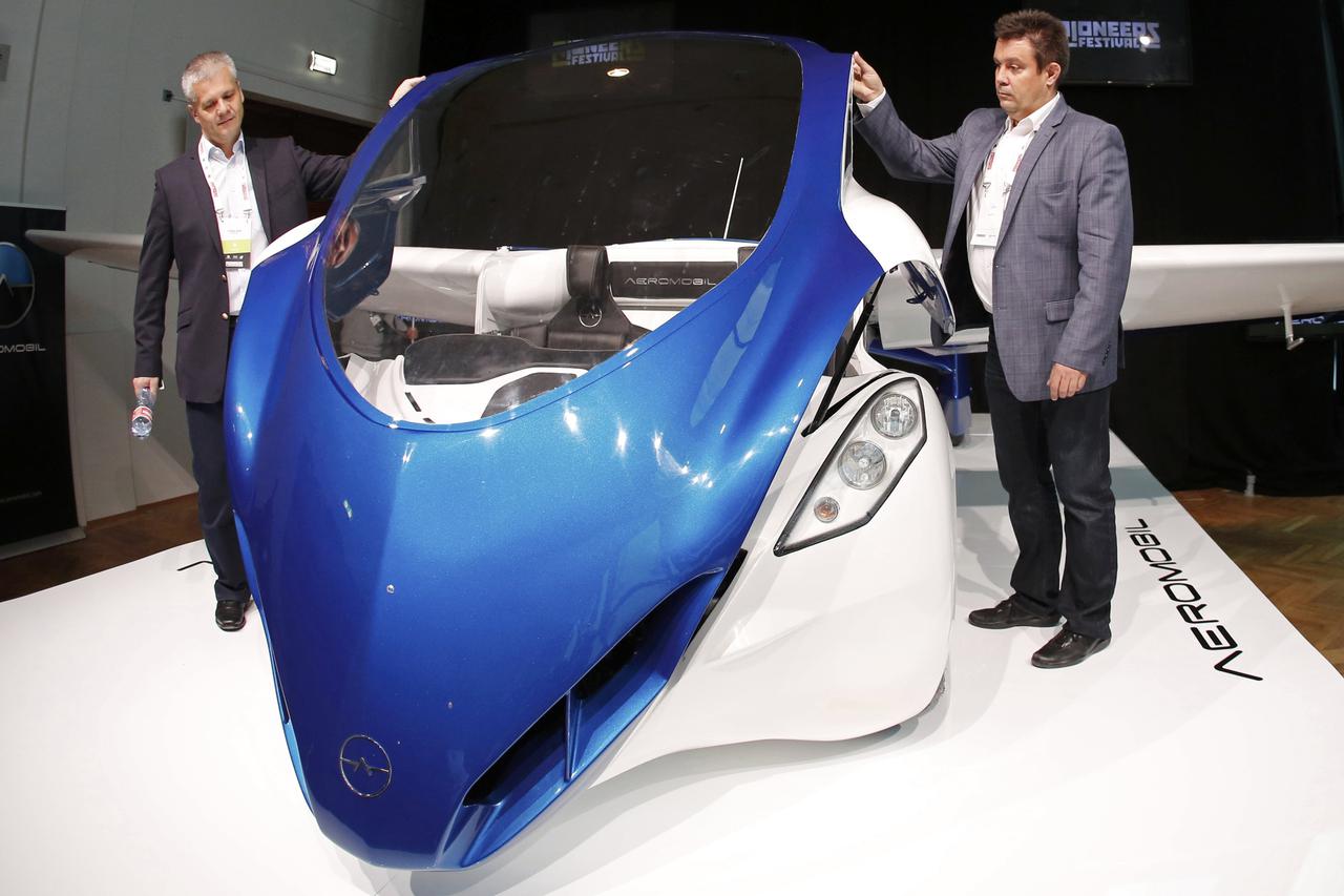 Two officials present the AeroMobil 3.0 during its world premiere at Hofburg Palace in Vienna October 29, 2014. The 