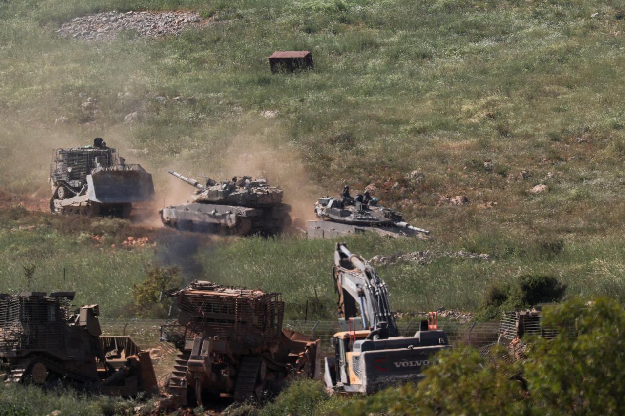 Tanks and an armoured vehicle drive in Lebanon, as seen from the Israeli side of the Israel-Lebanon border, in northern Israel