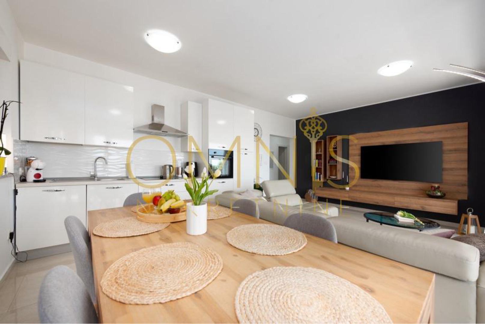 Dnevni boravak stanara očekuje s prostranošću i izlazom na balkon s kojeg se pruža panoramski pogled na Kvarner i more, dok je kuhinja opremljena modernim aparatima i blagovaonicom. 