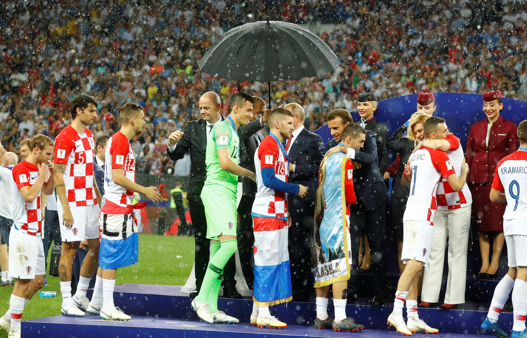 Samo jedan kišobran nad čelnicima tri države na dodjeli medalja na stadionu Lužnjiki nakon finala Svjetskog prvenstva fotografija je koja je obišla svijet.

