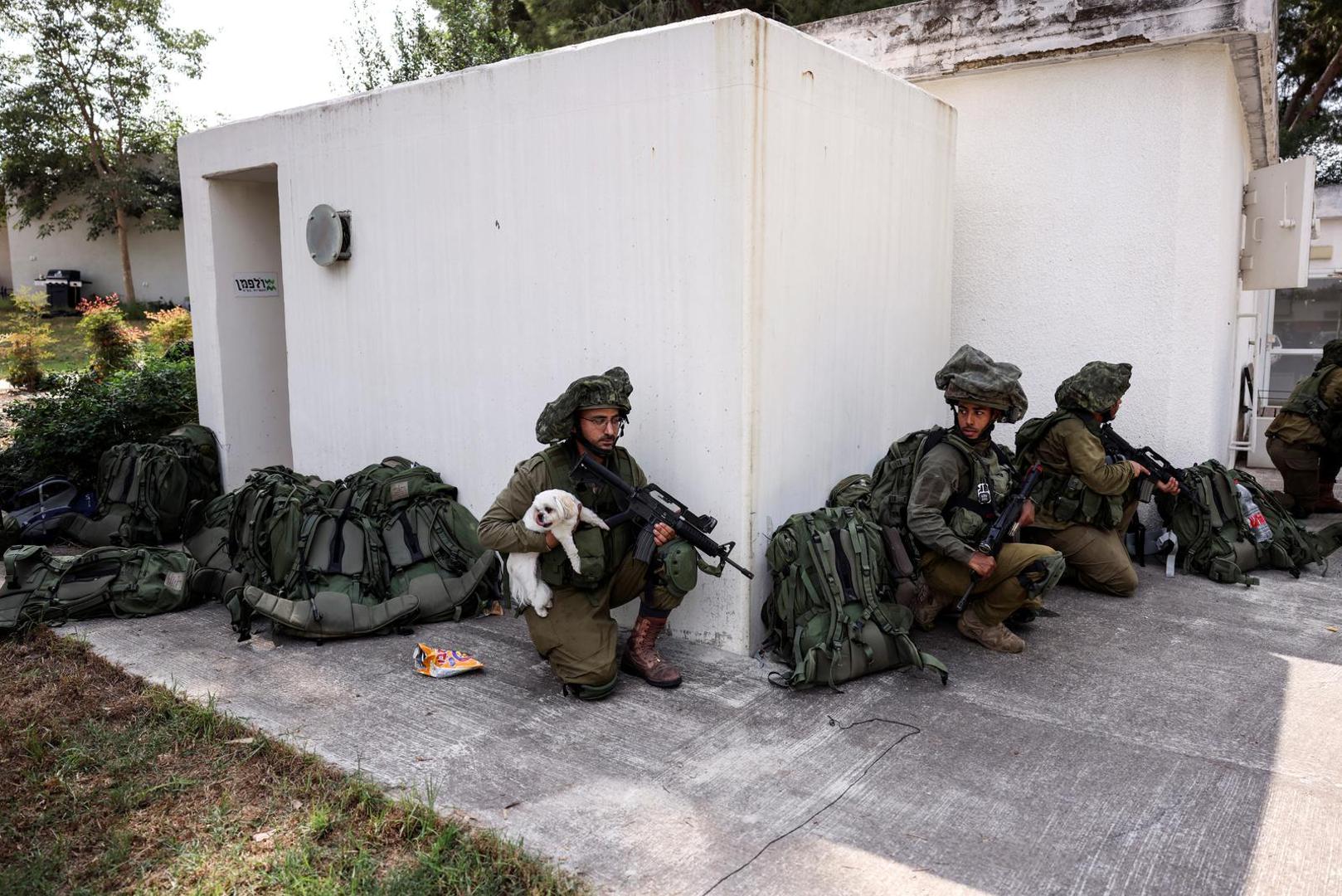 An Israeli soldier holds a rescued dog as he takes position near a bomb shelter in Kibbutz Kfar Aza, in southern Israel, October 10, 2023. REUTERS/Ronen Zvulun Photo: RONEN ZVULUN/REUTERS