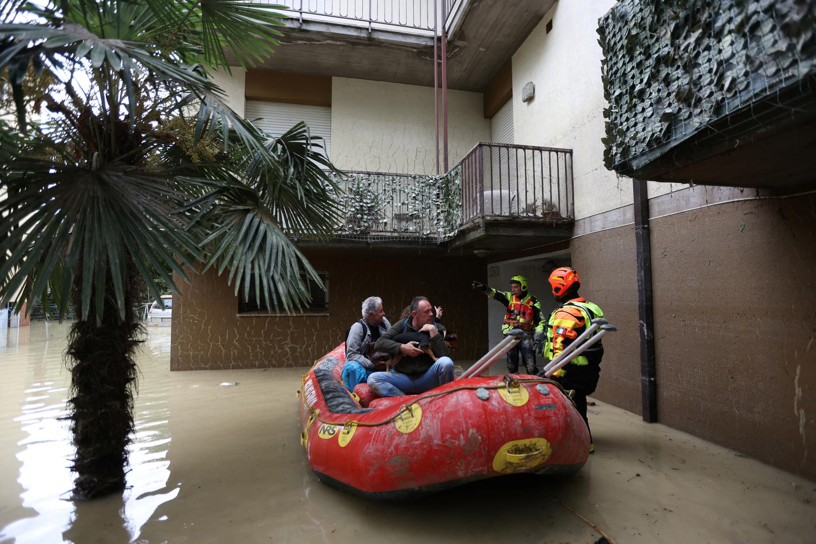 Firefighters evacuate people with a dog from a flooded house, after heavy rains hit Italy's Emilia Romagna region, in Faenza, Italy, May 18, 2023. REUTERS/Claudia Greco Photo: CLAUDIA GRECO/REUTERS
