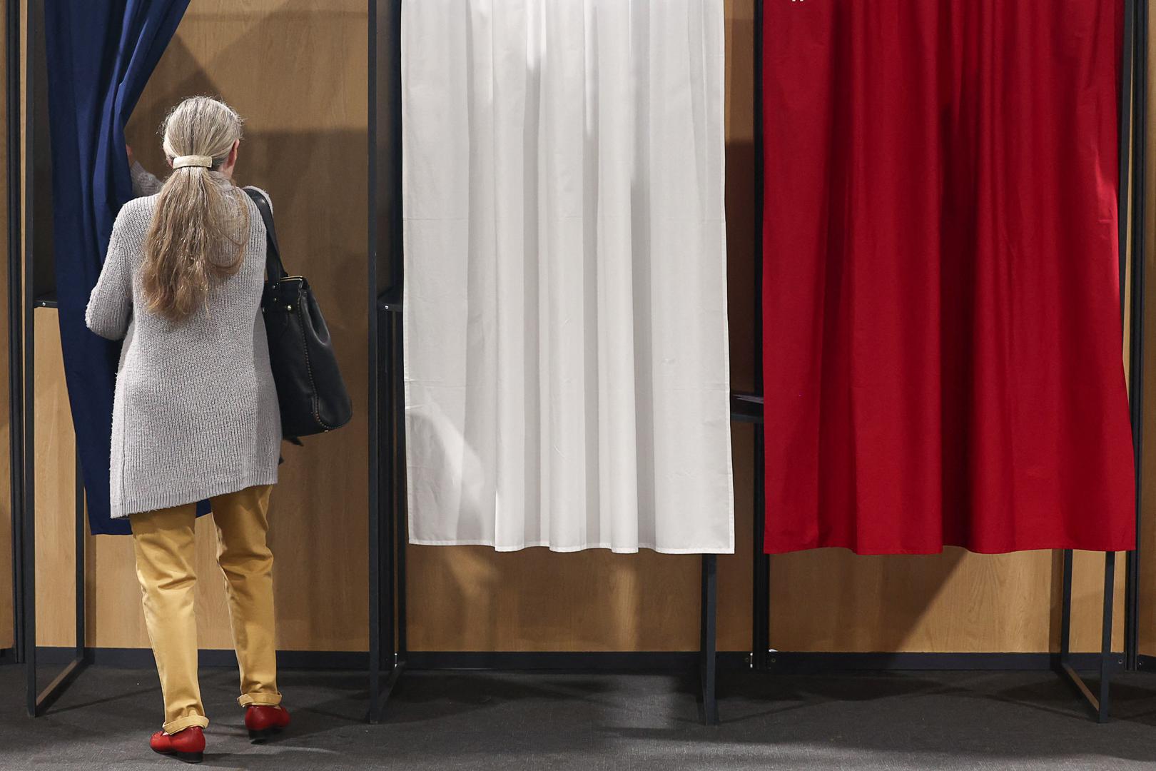 A woman enters a voting booth, to vote in the first round of the early French parliamentary elections at a polling station in Le Touquet-Paris-Plage, France, June 30, 2024. REUTERS/Yara Nardi Photo: YARA NARDI/REUTERS
