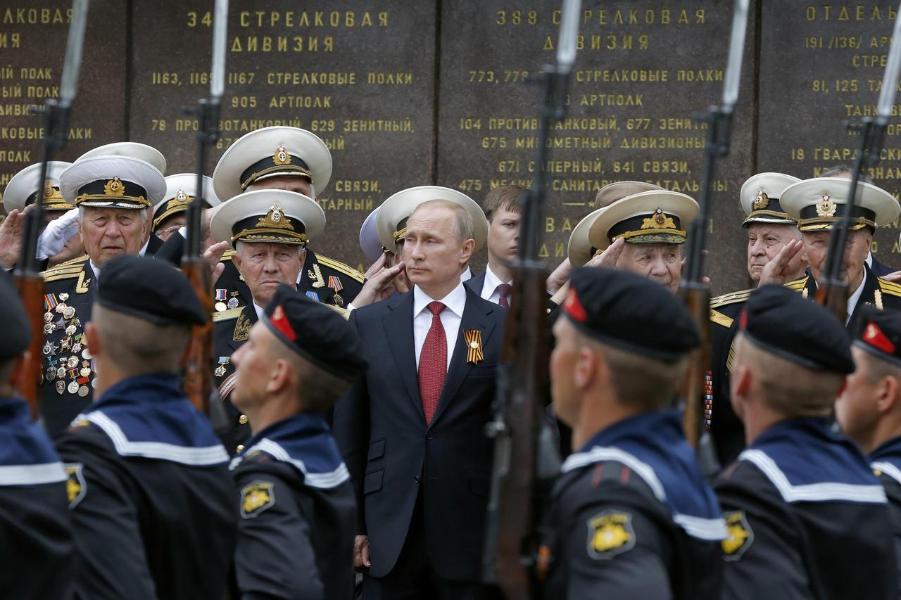 Russian President Vladimir Putin (C) stands with military personnel during a ceremony marking Victory Day in Sevastopol in this May 9, 2014 file photo. To match Special Report UKRAINE-CRISIS/RUSSIANS REUTERS/Maxim Shemetov/Files   (CRIMEA  - Tags: POLITIC