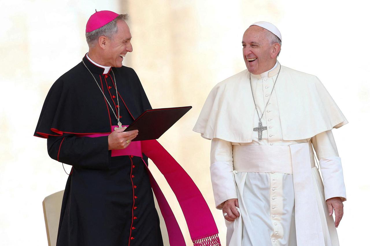 FILE PHOTO: Pope Francis smiles as he talks with Archbishop Georg Ganswein at the end of his Wednesday general audience in Saint Peter's square at the Vatican