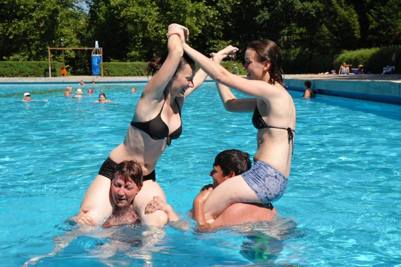 'zagorje - 24. 07. 2009., Sutinske Toplice, Hrvatska - Kceri Patricija i Gordana, majka Ines i prijatelj Marko iz Lepoglave zabavljaju se u bazenu boreci se tko ce koga srusiti u vodu. U Sutinske Topl