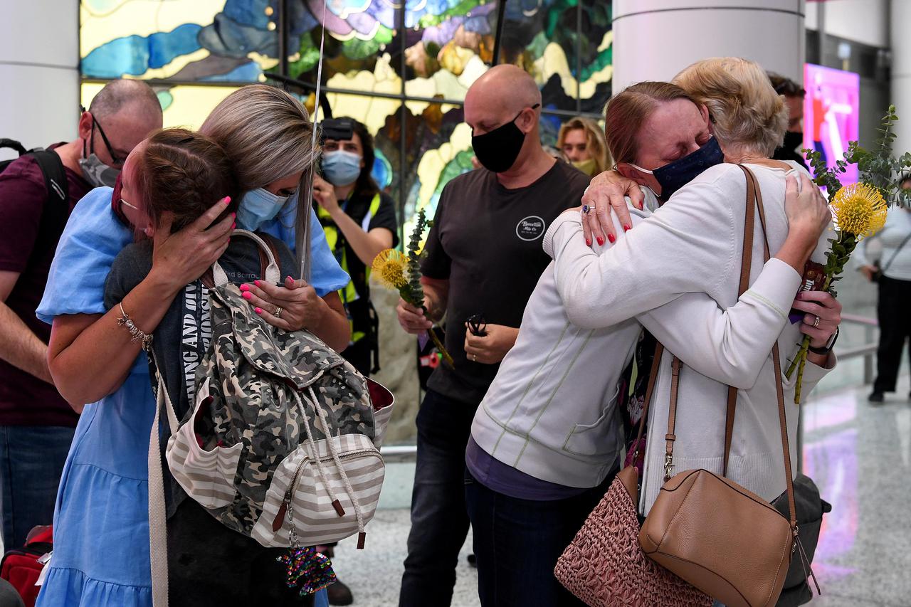 Travellers arriving on the first quarantine free international flights are embraced by family at Sydney International Airport
