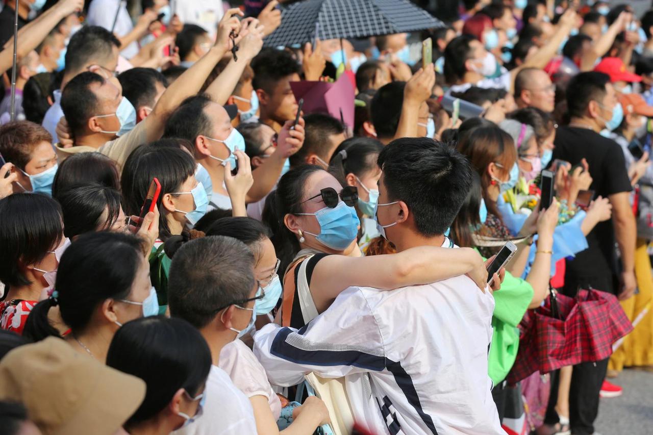 Woman embraces a student during annual national college entrance exam, or "gaokao", in Wuhan