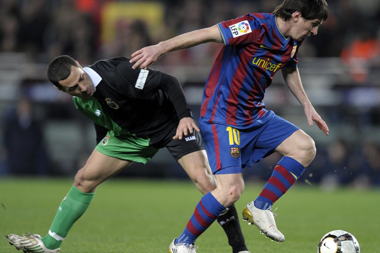 'Barcelona\'s Argentinian forward Lionel Messi (R) vies with Racing Santander\'s French midfielder Mehdi Lacen during a Spanish League football match at the Camp Nou Stadium in Barcelona, on February 