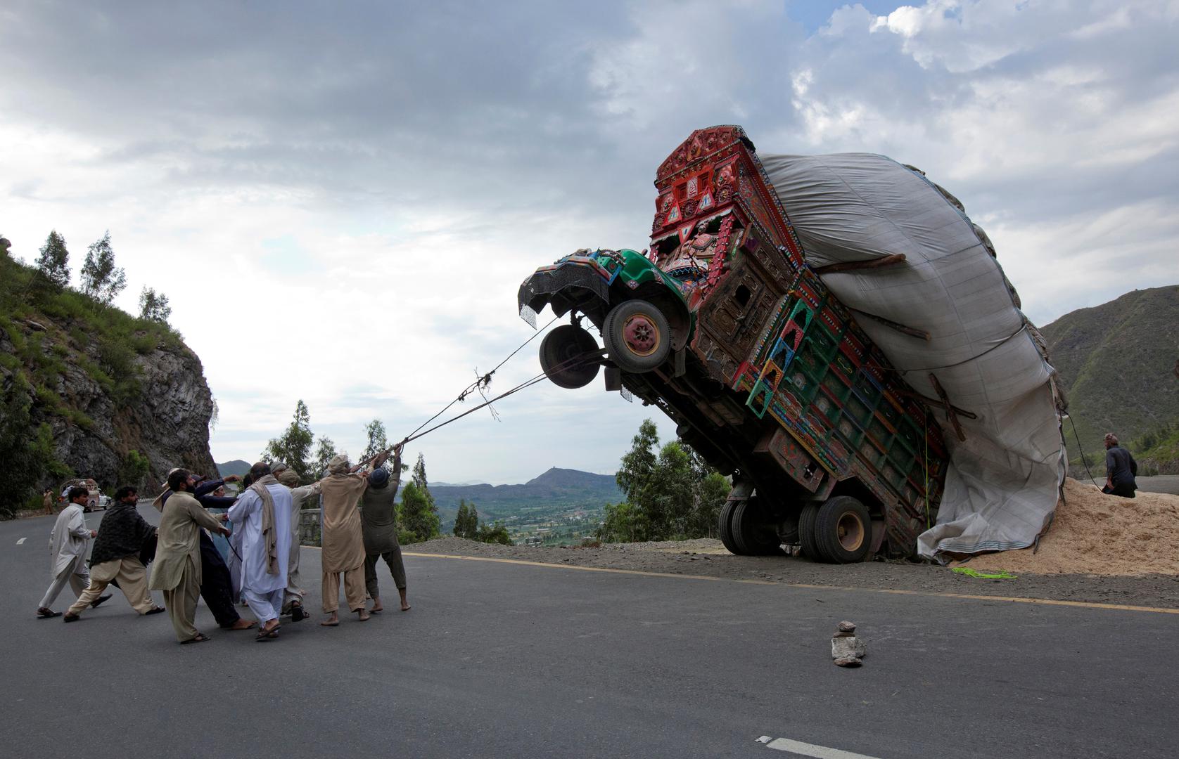 Konopcima pokušavaju ispraviti preopterećeni kamion. Snimljeno 13. travnja 2012. oko 165 km od Islamabada