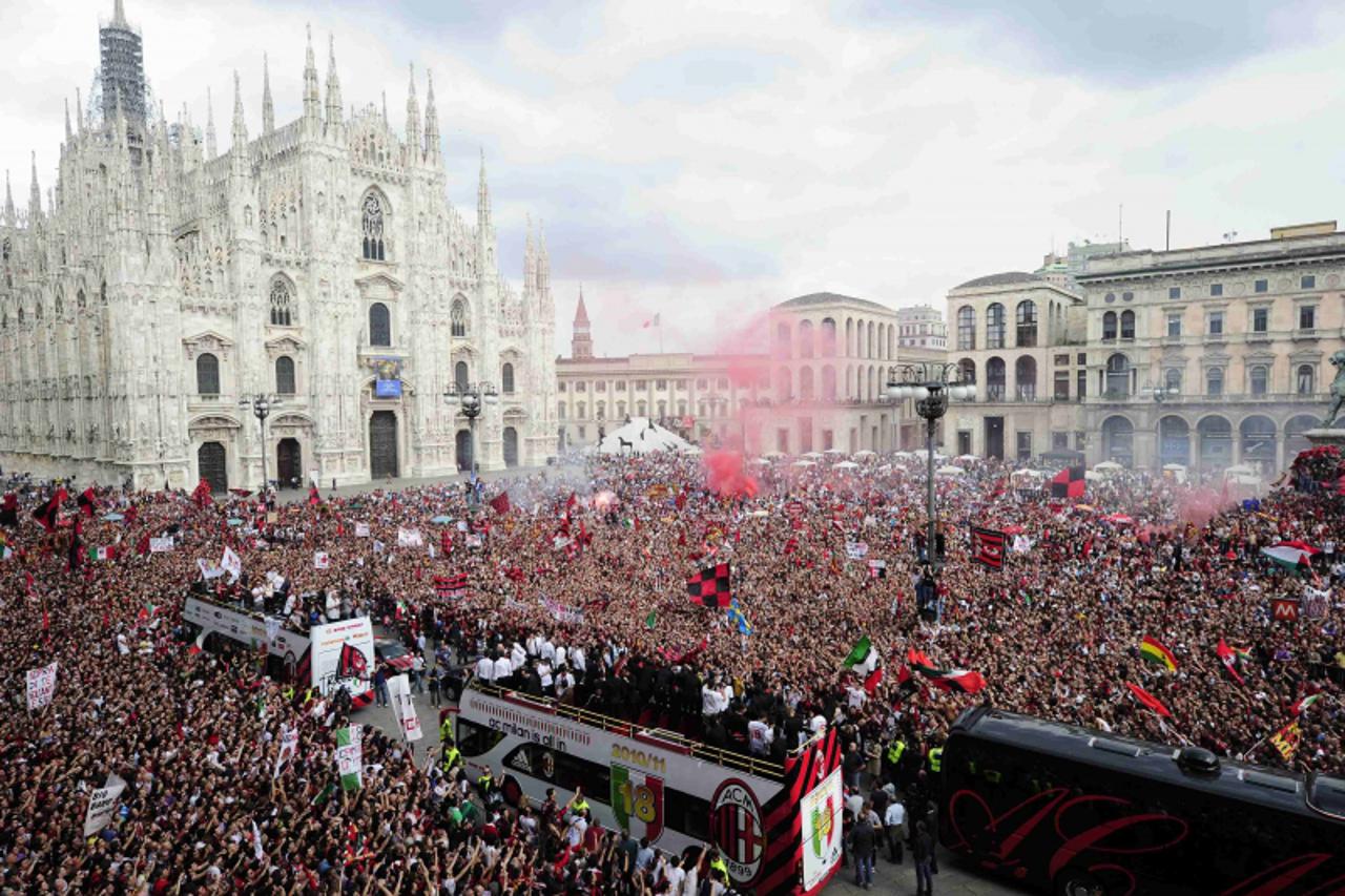 'AC Milan\'s players and staff celebrate on a bus after the team won their 18th Italian Serie A title, in Duomo square, downtown Milan, May 14, 2011. REUTERS/Paolo Bona (ITALY - Tags: SPORT SOCCER)'