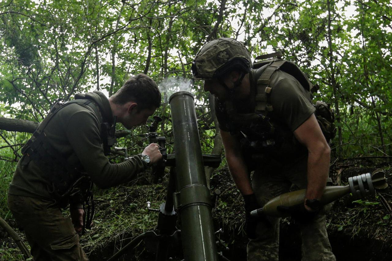 Ukrainian servicemen fire a mortar towards Russian troops near a frontline in Donetsk region
