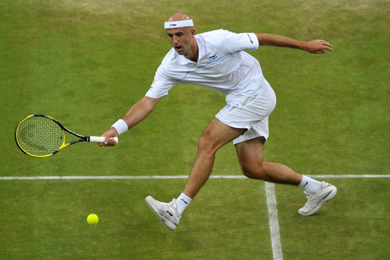 \'Croatian player Ivan Ljubicic returns the ball to British player Andy Murray during the men\'s single at the Wimbledon Tennis Championships at the All England Tennis Club, in southwest London on Jun
