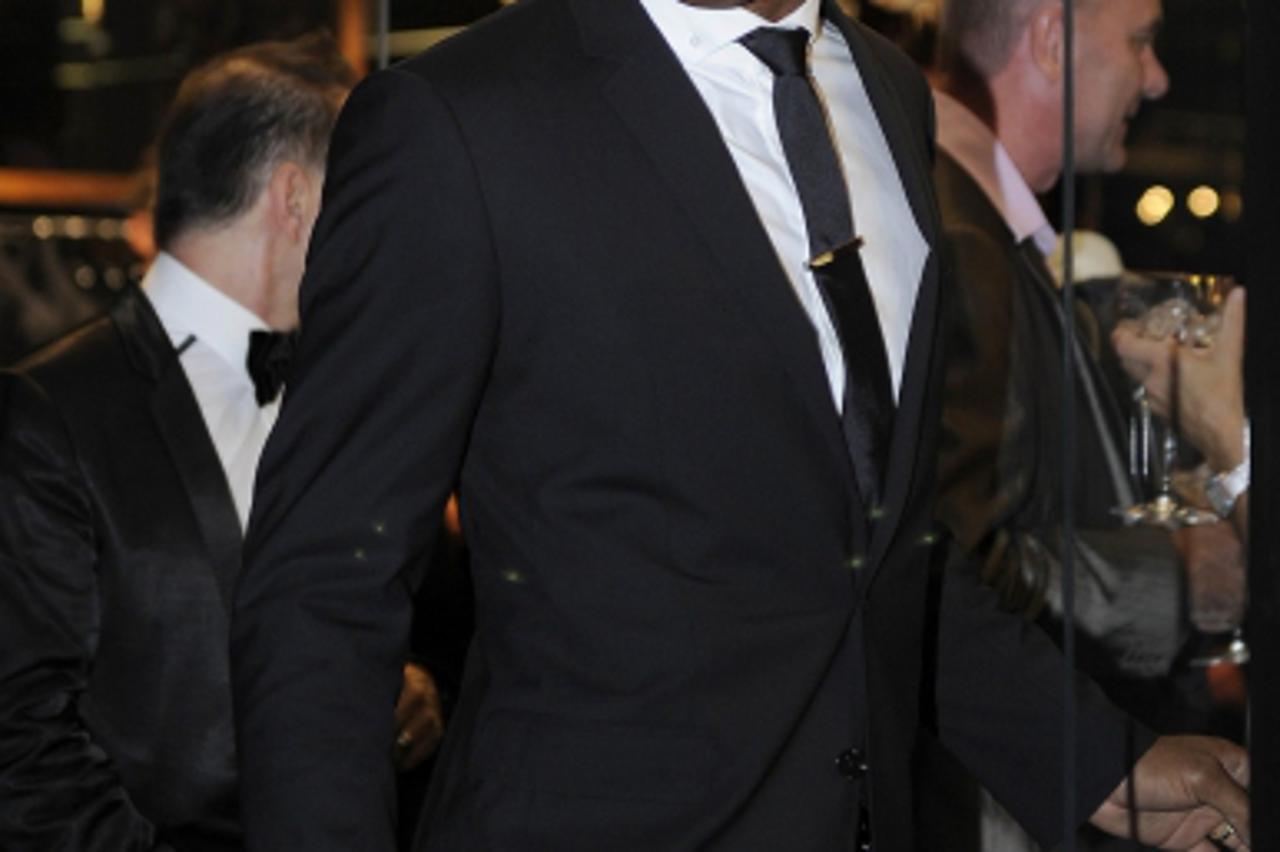 \'Chelsea and Ivory Coast soccer player Didier Drogba poses for photographers as he arrives at a Dolce and Gabbana shop for a party to mark the 25th anniversary of model Naomi Campbell\'s career, in c