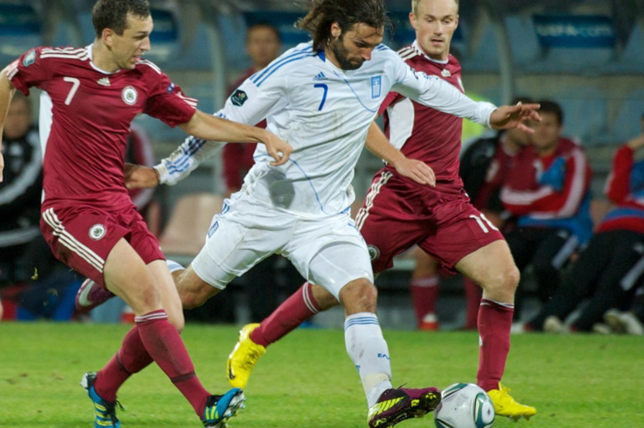 'Greece Georgios Samaras (C) vies with Latvia\'s Olegs Laizans (L) and Aleksejs Visnakovs (R) during their Euro 2012 group F qualification football match at the Skonto Stadium in Riga, on September 6,