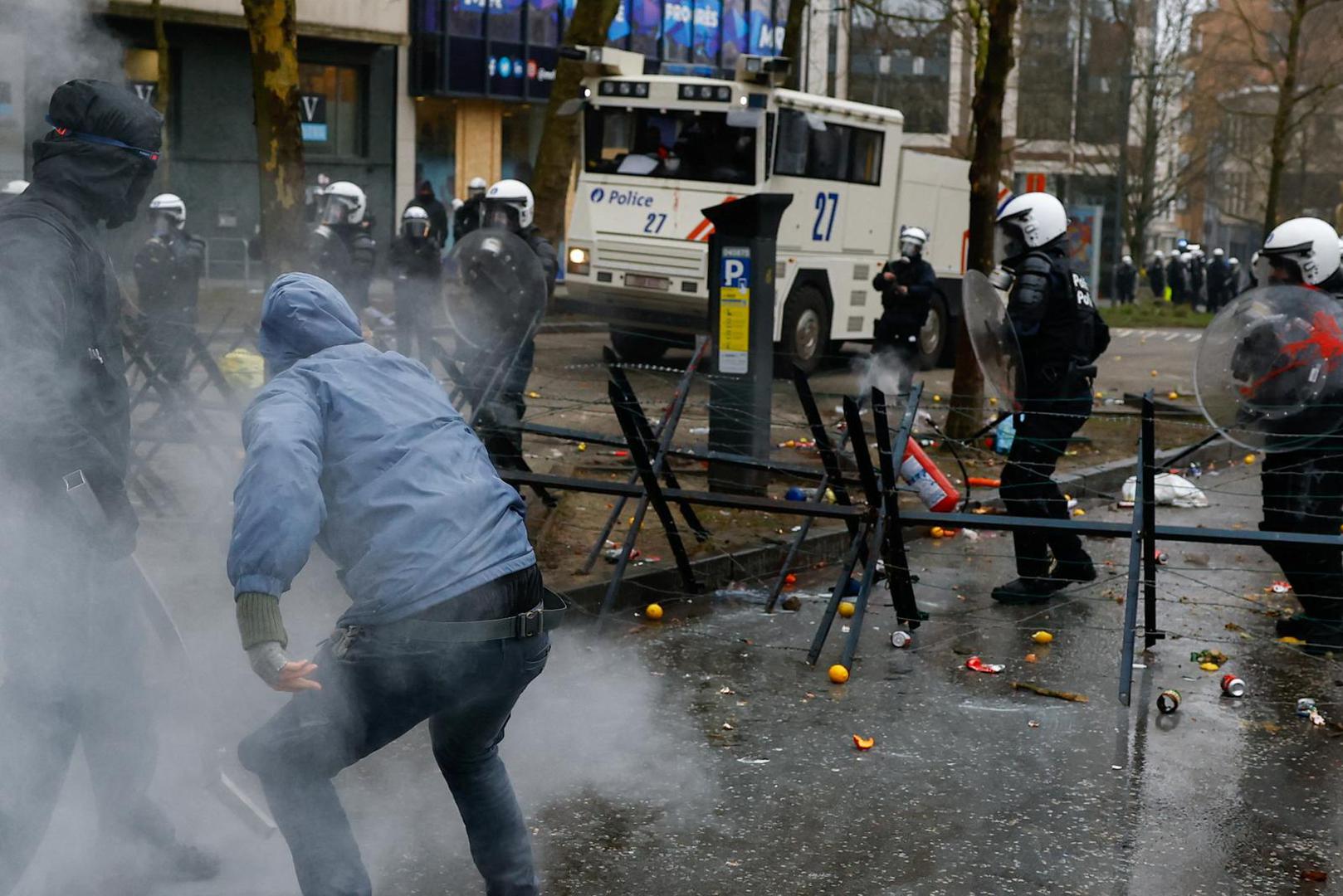 A protester throws fire extinguisher at riot police, as another approaches with a metal bar, at a national strike by workers and trade union members, who are demanding stronger public services in Brussels, Belgium February 13, 2025. REUTERS/Stephanie Lecocq Photo: STEPHANIE LECOCQ/REUTERS